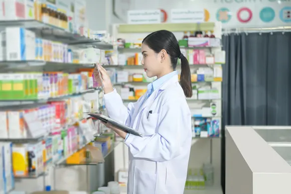 Portrait of female pharmacist using tablet in a modern pharmacy drugstore