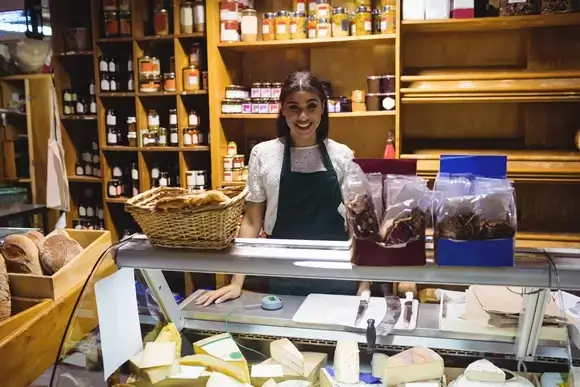 female staff standing cheese counter