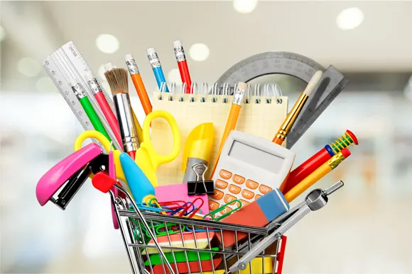 Colorful office supplies in shopping cart